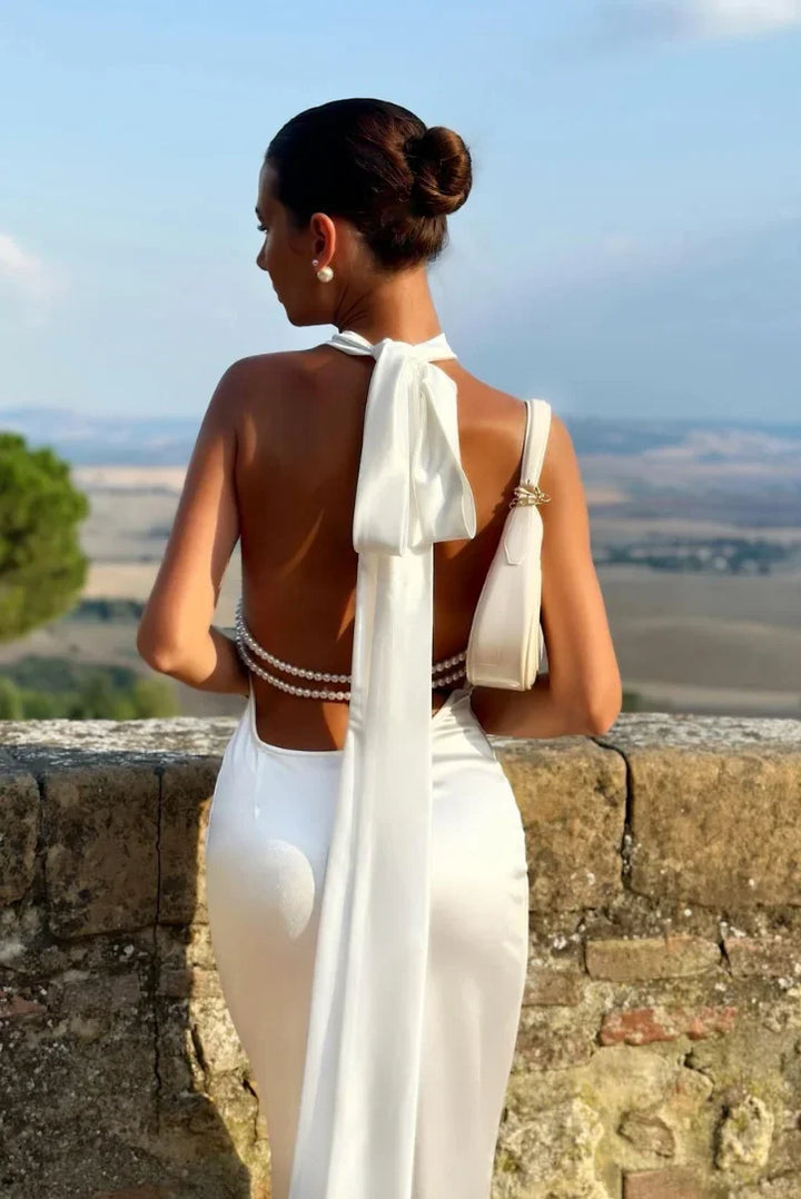 Women's white backless maxi dress with pearl accents and bow